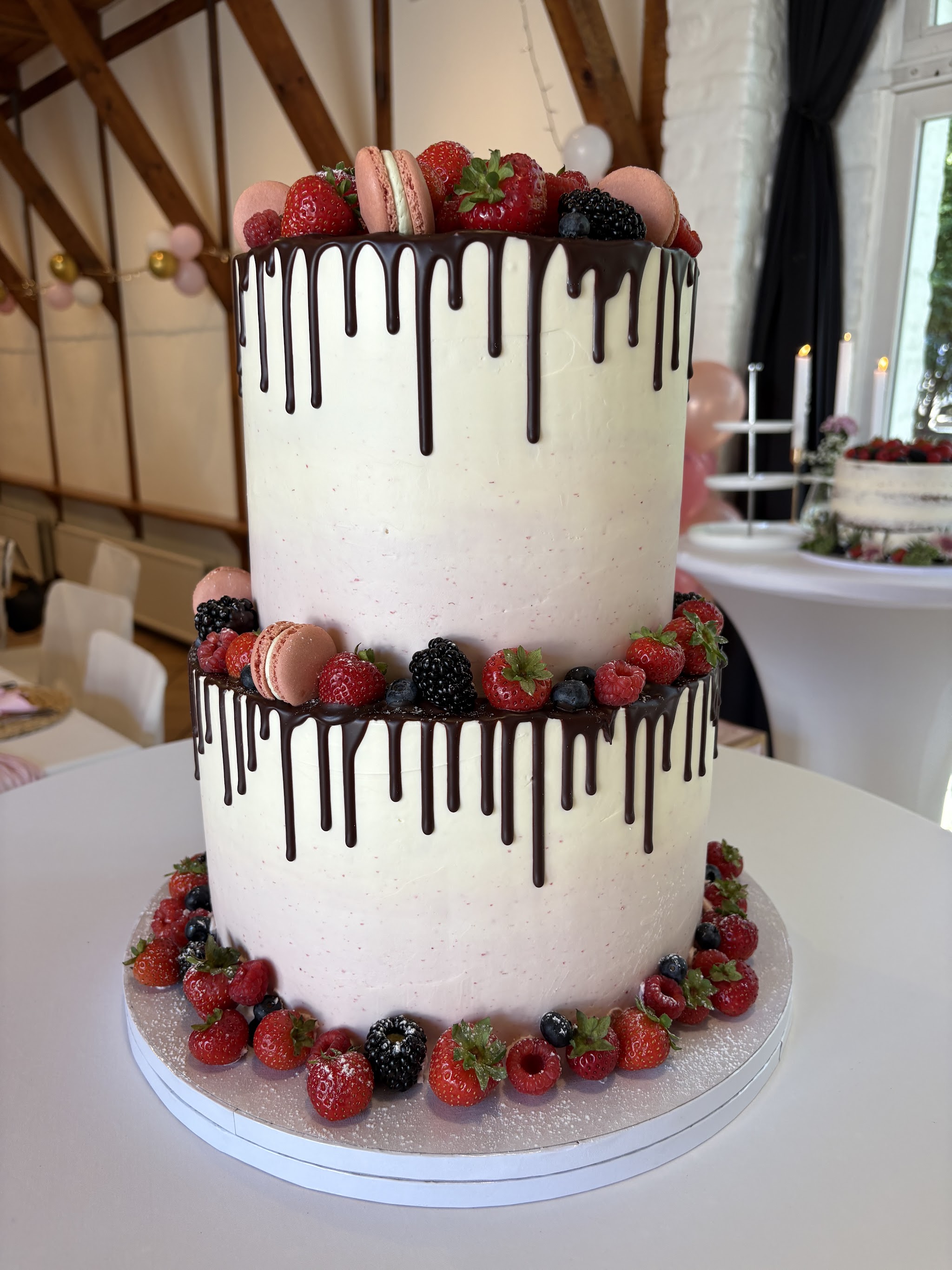 Zweistöckige Drip-Cake mit Beeren und Macarons