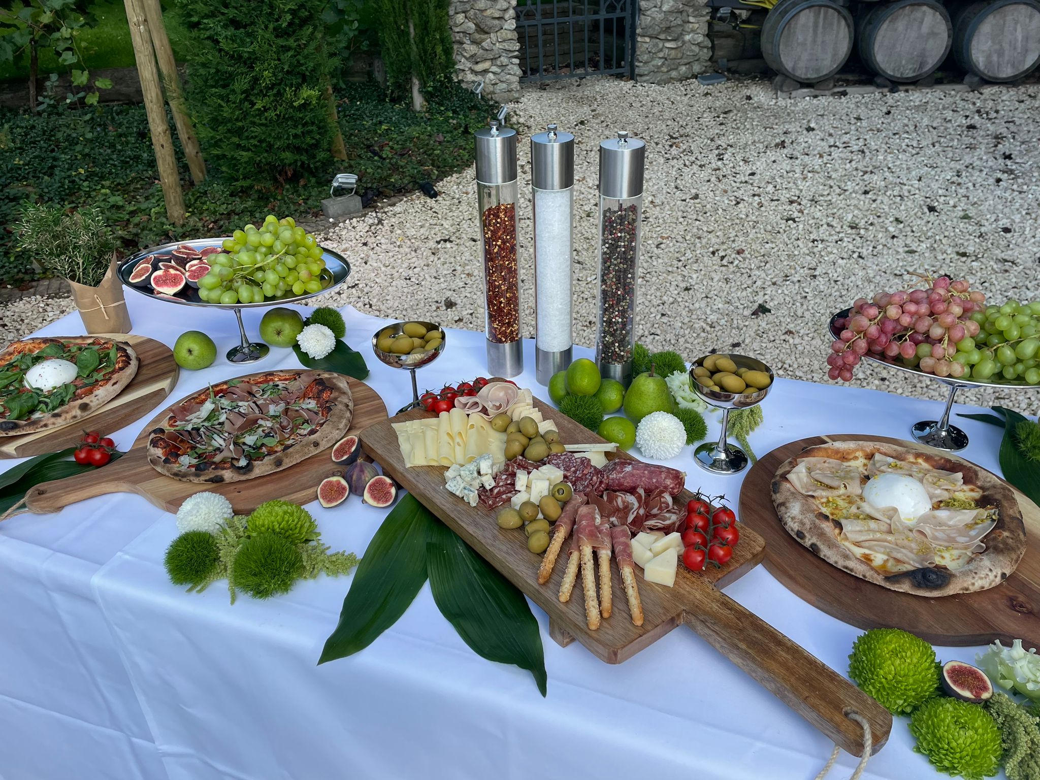 Outdoor-Buffet mit Pizza, Antipasti-Brett, Oliven, Trauben und Feigen