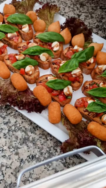 Caprese-Crostini mit Basilikum auf weißer Platte
